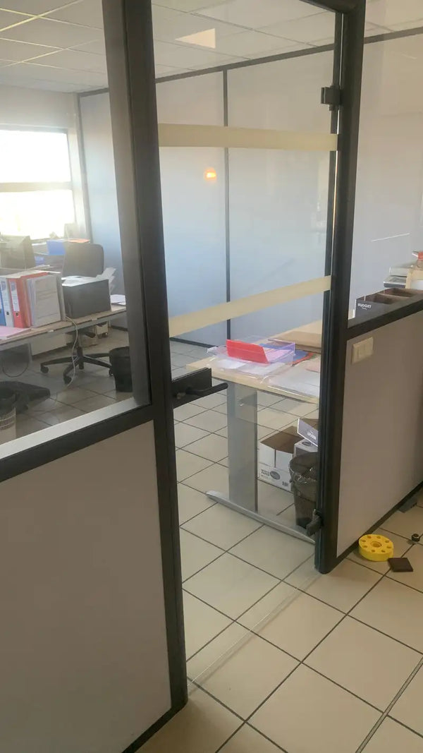 Bandes de repérage posées sur une cloison vitrée de bureau