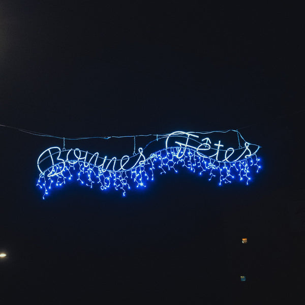 Bonnes fêtes vagues en situation en traversée de rue, de nuit, ici en bleu