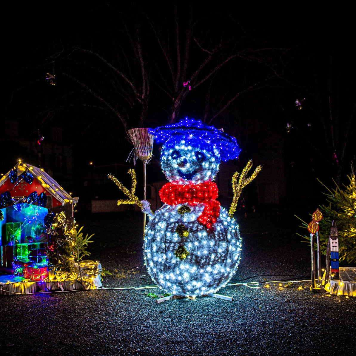 Bonhomme de neige en situation dans un décor de Noël, de nuit