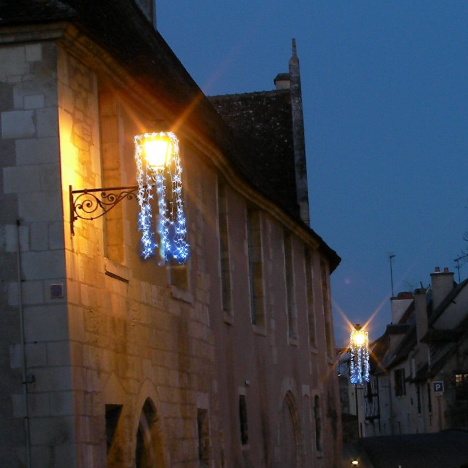 Nuisette bleu blanc en situation sur une lanterne de façade, à la tombée de la nuit