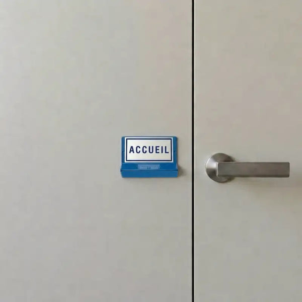 Plaque braille posée à côté d'une porte