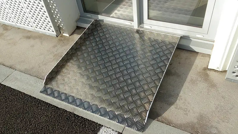 Rampe aluminium posée devant une porte vitrée
